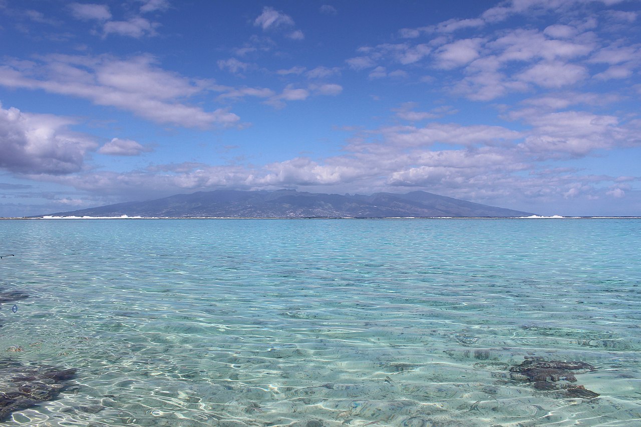 Turquoise lagoon at Plage de Temae, Moorea, with Tahiti on the horizon